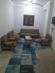 a living room with couches and tables on a tile floor at العلمين هوسيز in El Alamein