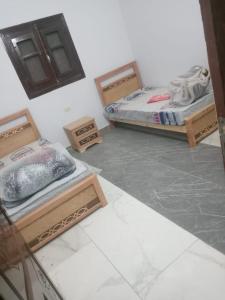 a room with three beds in a room at العلمين هوسيز in El Alamein
