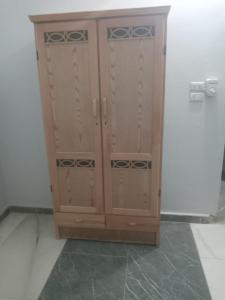 a wooden cabinet is sitting in a room at العلمين هوسيز in El Alamein