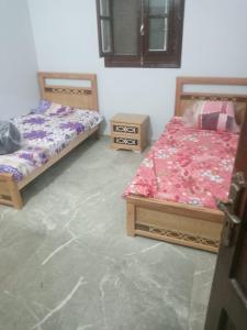 a bedroom with two beds and two night stands at العلمين هوسيز in El Alamein
