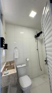 a bathroom with a toilet and a sink at Chácara encantos Iranduba in Iranduba +11 photos