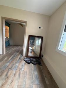 an empty room with a mirror on the floor at La rose Poncet in Gardegan-et-Tourtirac