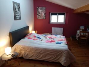 a bedroom with a large bed in a red wall at Laroclya in Lilhac +16 photos