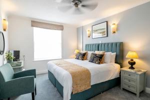 a bedroom with a bed and a chair and a window at SACO Jersey - Merlin House in Saint Helier Jersey