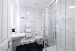 a bathroom with a toilet and a sink and a shower at SACO Jersey - Merlin House in Saint Helier Jersey +33 photos