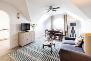 a living room with a blue couch and a table at SACO Jersey - Merlin House in Saint Helier Jersey