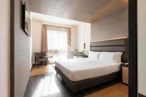 ein Hotelzimmer mit einem weißen Bett und einem Tisch in der Unterkunft Warmthotel in Rom + 73 Fotos