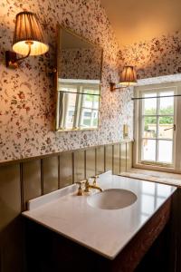 a bathroom with a sink and a mirror at The Norman Knight in Whichford