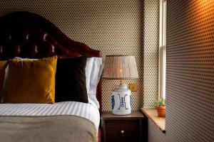 a bedroom with a bed and a lamp on a table at The Norman Knight in Whichford +6 photos