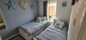 a bedroom with two beds and stars on the wall at The cosy house in Corton +7 photos