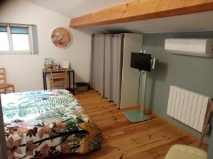 a bedroom with a bed and a flat screen tv at Laroclya in Lilhac