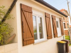 three windows on the side of a house with wooden doors at Road Stop Studio - Paris - Disney- Train Station in Chelles