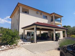 a house with a gazebo in front of it at Apartmani Masline Međugorje in Međugorje