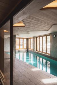a swimming pool in a building with windows at Le Taos in Tignes