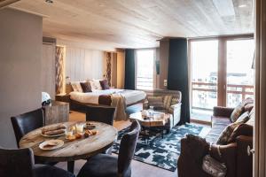 a hotel room with a bed and a table and chairs at Le Taos in Tignes