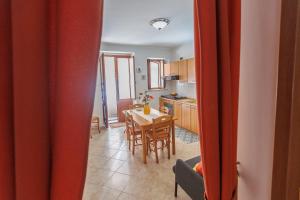 a kitchen and dining room with a table and chairs at Casa Lina - 10 minuti da Pantalica-parcheggio gratuito in Sortino +12 photos