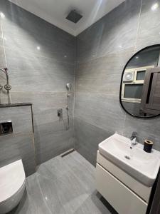 a bathroom with a sink and a toilet and a mirror at Spacious 3BR Apartment in Prime Sheikh Zayed in Sheikh Zayed +9 photos