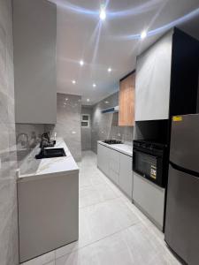 a kitchen with white cabinets and a black appliance at Spacious 3BR Apartment in Prime Sheikh Zayed in Sheikh Zayed