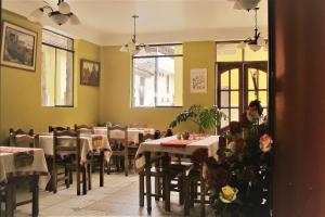 a dining room with tables and chairs and windows at Tumy house B&B in Ollantaytambo