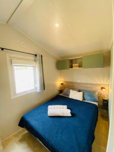 a small bedroom with a blue bed with a window at Premium Sea View in Saint-Raphaël +18 photos