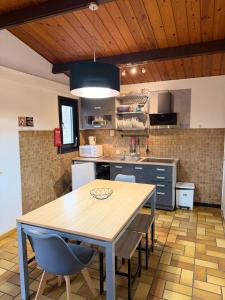 a kitchen with a wooden table and chairs at Cabana 16 in Petit Mesnil