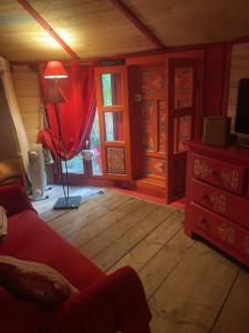 a living room with a red couch and wooden floors at B&B L'Albatros in Fayence