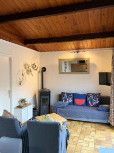 a living room with a blue couch and a tv at Cabana 16 in Petit Mesnil