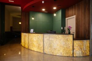 eine Lobby mit Theke und einer grünen Wand in der Unterkunft Hotel Guardamar in Guardamar del Segura + 199 Fotos