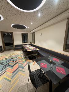 a conference room with tables and chairs and a colorful rug at LEON D'ORO - Art Hotel in Pieve di Soligo