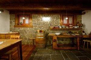 a room with a stone wall and a table and a barrel at Hotel Garni Plueme in Sauris