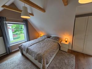 a bedroom with a bed and a large window at Ferienwohnungen Stilschön in Warnemünde