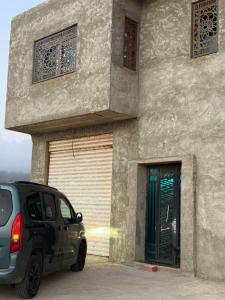 a car parked in front of a building with a garage at Azure Coast Residence in Mostaganem