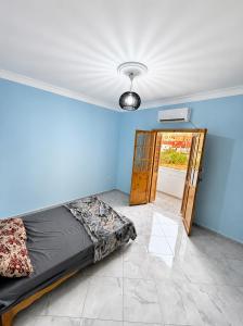 a bedroom with a bed in a room with a door at Azure Coast Residence in Mostaganem