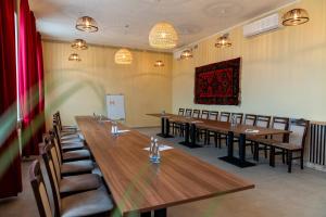 a conference room with wooden tables and chairs at Mangal Hotel in Olgina