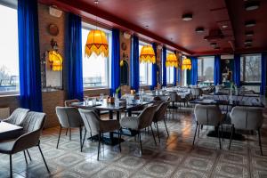 a dining room with tables and chairs and windows at Mangal Hotel in Olgina