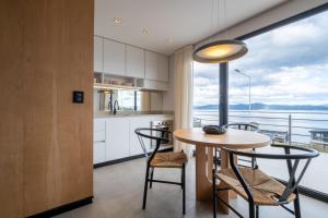 a kitchen with a table and chairs and a large window at Costa Susana Ushuaia in Ushuaia