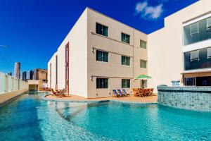 a building with a swimming pool in front of a building at Átrios Beach Hotel in Natal