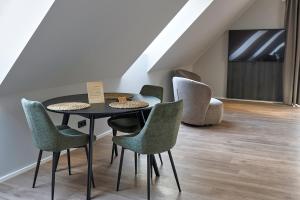ein Esszimmer mit Stühlen, einem Tisch und einem Fernseher in der Unterkunft STORK's NEST in Schrobenhausen