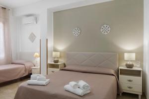 a bedroom with two beds with towels on the bed at Demetra Malophoros in Marinella di Selinunte