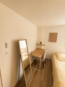 a room with a table and a mirror and a bed at Chambre Studio privé in Villenave-dʼOrnon