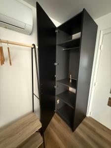 a black cabinet in the corner of a room at Chambre Studio privé in Villenave-dʼOrnon