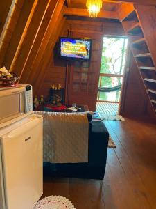 a living room with a tv in a cabin at Chalé Premium com jacuzzi privativa Florianópolis in Florianópolis +28 photos