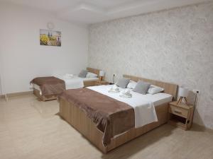a bedroom with two beds and a wall at Apartmani Masline Međugorje in Međugorje