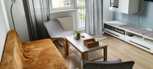 a living room with a couch and a table at Przystań Kamień Centrum in Kamień Pomorski