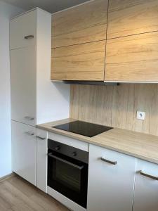 a kitchen with white cabinets and a stove top oven at Przystań Kamień Centrum in Kamień Pomorski +6 photos