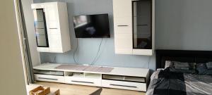 a bedroom with a tv and a white cabinet at Przystań Kamień Centrum in Kamień Pomorski