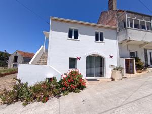 a white house with flowers in front of it at Maison proche Fatima batalha in Reguengo do Fetal