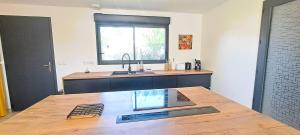 a kitchen with a wooden table with a sink at L'expérience quiétude espace modernité à Salles in Salles +44 photos