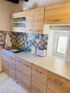 a kitchen with wooden cabinets and a counter top at Plativola Mountain View in Sitia