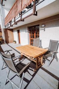 a wooden table and chairs on a patio at Apartmány s výhledem in Horní Maršov